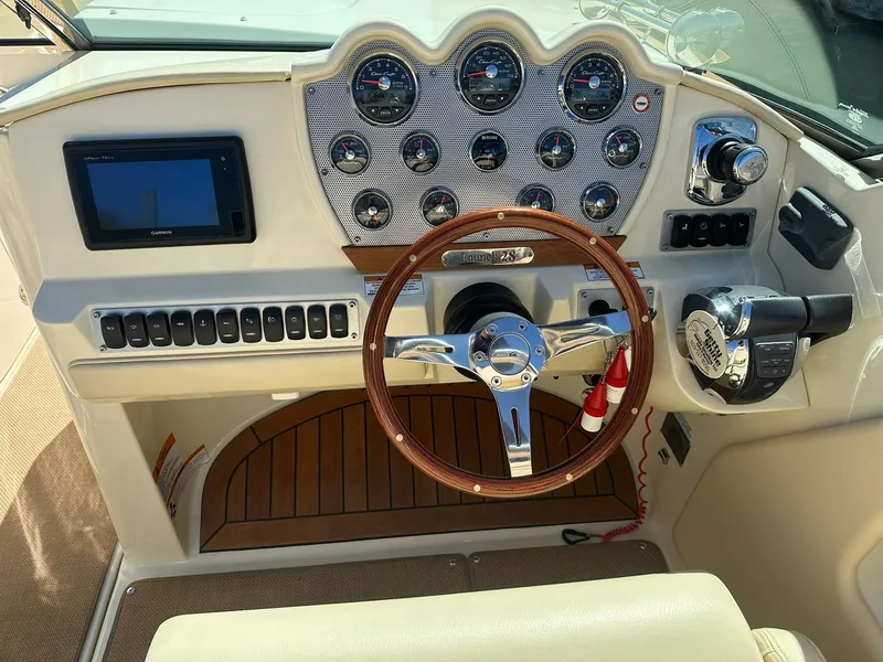 Slide: The Image of 2016 Chris-Craft Launch 28 dashboard with wooden steering wheel and modern controls. - 14