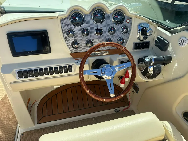 Slide: The Image of 2016 Chris-Craft Launch 28 dashboard with wooden steering wheel and modern controls. - 15