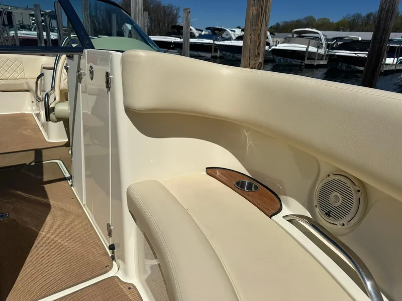 Slide: The Image of 2016 Chris-Craft Launch 28 interior with beige seating and cup holder, docked at marina. - 20