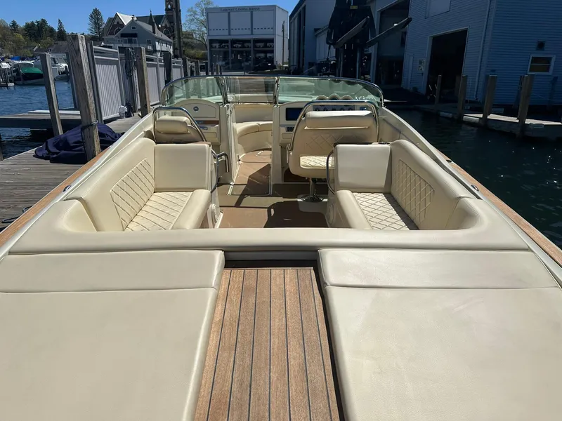 Slide: The Image of 2016 Chris-Craft Launch 28 with beige seating and wooden deck, docked at a marina. - 9