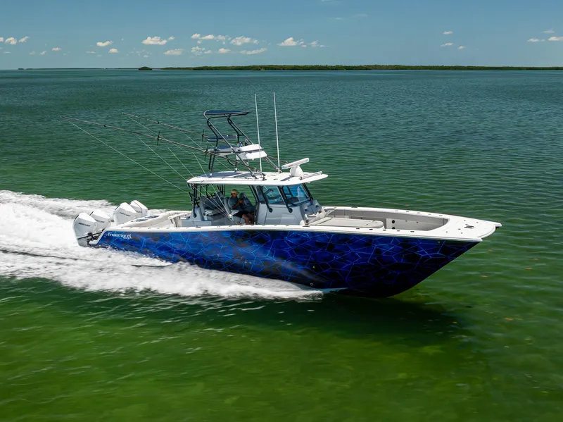 The Image of 2021 Freeman 42 LR boat cruising on open water, vibrant blue design, clear sky. - 0