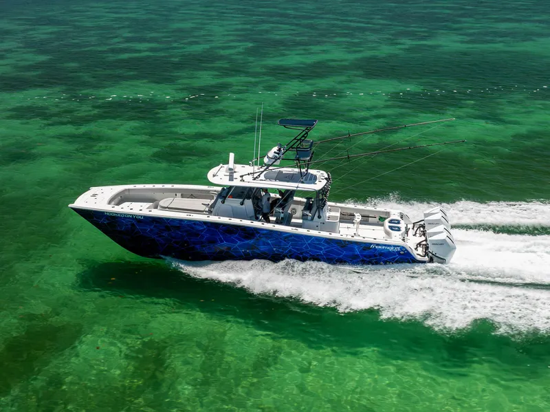 Slide: The Image of Freeman 42 LR 2021 boat cruising on clear turquoise waters, aerial view. - 12