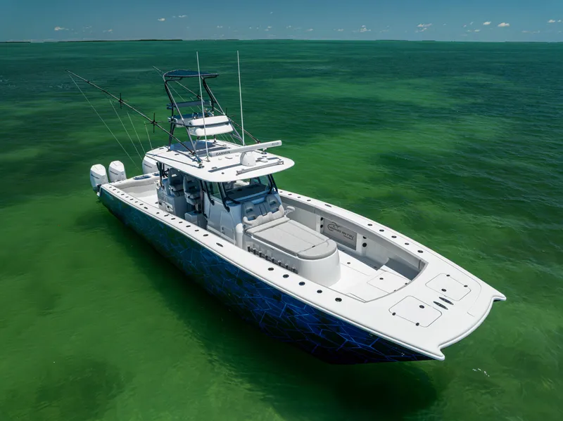 Slide: The Image of 2021 Freeman 42 LR boat on clear green water, featuring dual engines and fishing equipment. - 2