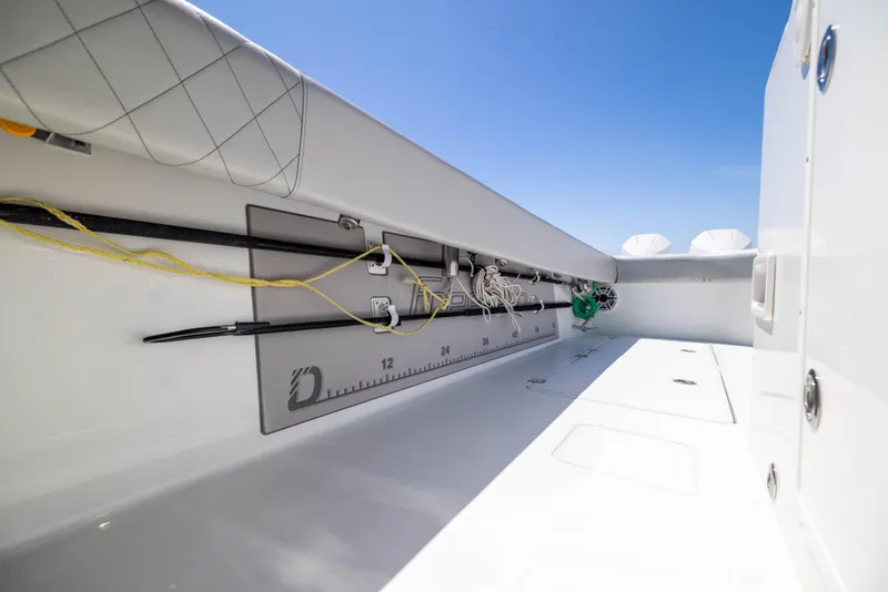 Slide: The Image of Interior view of a 2021 Freeman 42 LR boat, featuring fishing rod holders and a measuring ruler. - 28