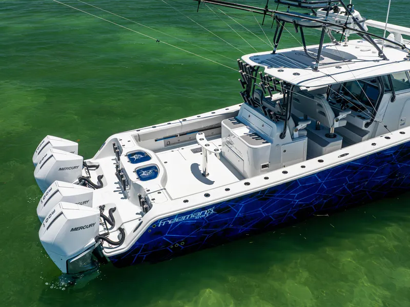 Slide: The Image of Freeman 42 LR 2021 boat with Mercury engines on clear green water. - 7