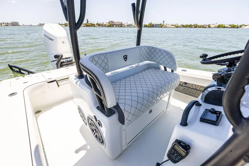 Slide: The Image of 2020 Barker Boatworks 26 interior with cushioned seating and control panel on the water. - 15