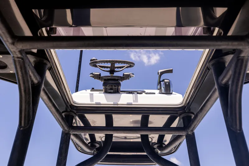 Slide: The Image of 2020 Barker Boatworks 26 helm view with steering wheel and controls against blue sky. - 17