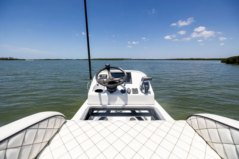 Slide: The Image of 2020 Barker Boatworks 26 on calm water, featuring a sleek helm and quilted seating. - 31