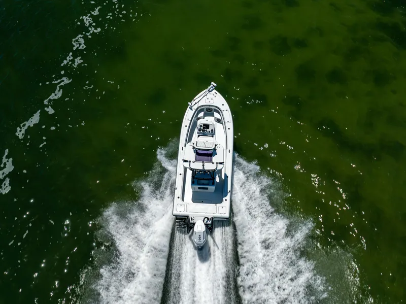 Slide: The Image of Aerial view of 2020 Barker Boatworks 26 cruising on green water. - 36
