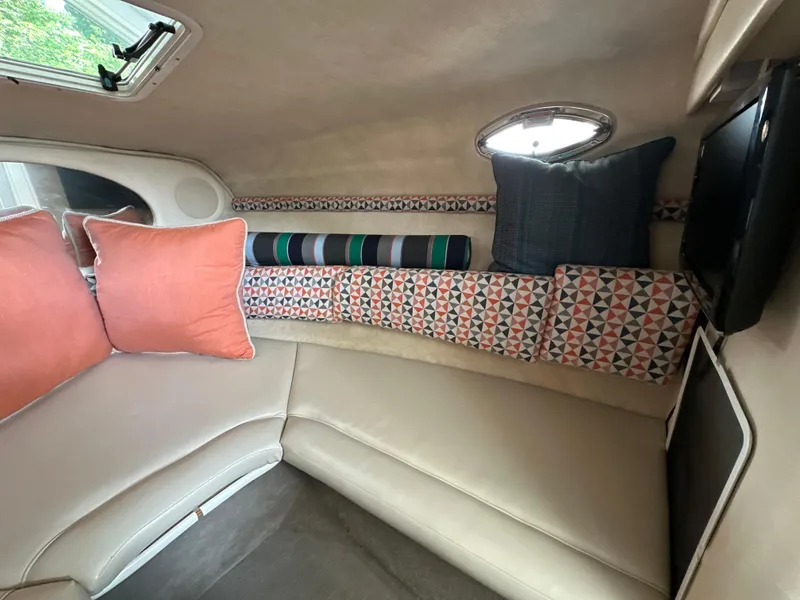 Slide: The Image of 2002 Sea Ray 240 Sundancer cabin interior with colorful cushions and seating. - 11