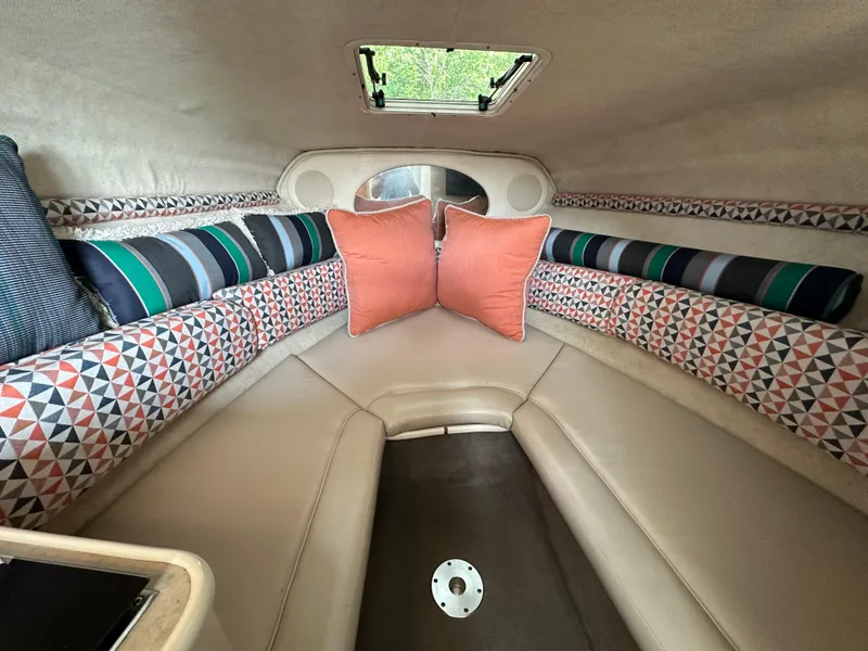 Slide: The Image of 2002 Sea Ray 240 Sundancer cabin interior with patterned cushions and pillows. - 12