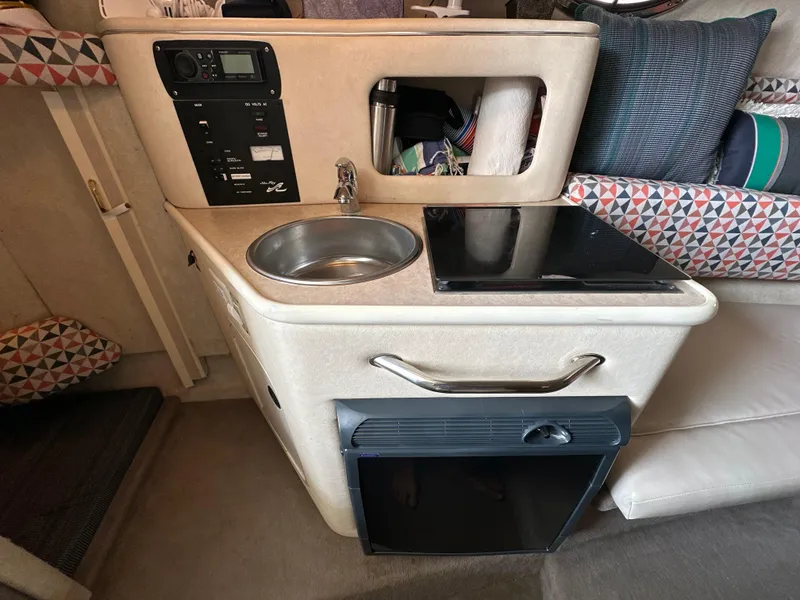 Slide: The Image of Compact kitchenette in 2002 Sea Ray 240 Sundancer with sink, stove, and storage. - 14