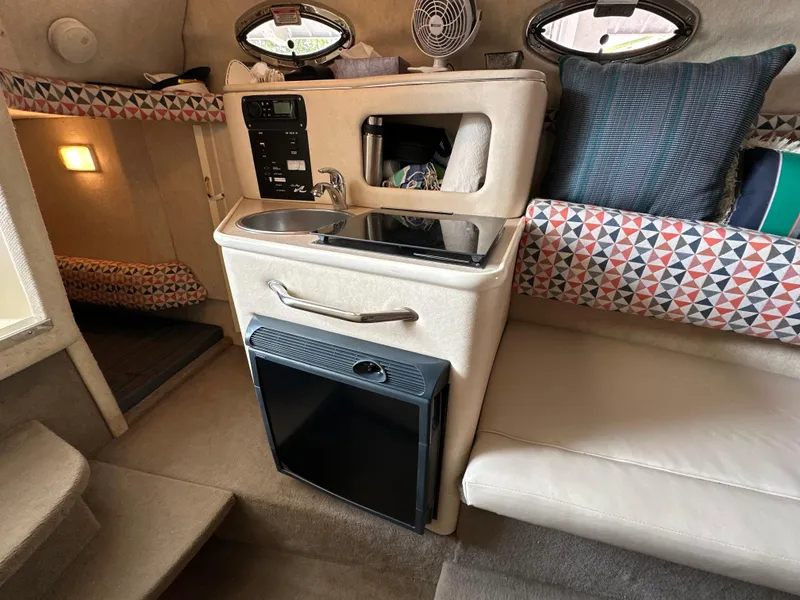 Slide: The Image of Interior of 2002 Sea Ray 240 Sundancer with kitchenette and seating area. - 15