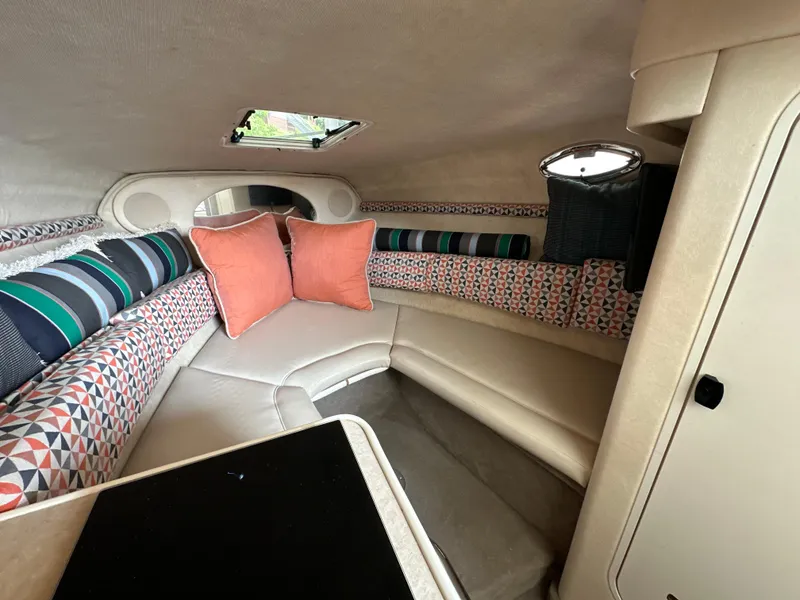 Slide: The Image of 2002 Sea Ray 240 Sundancer cabin interior with colorful cushions and seating area. - 16