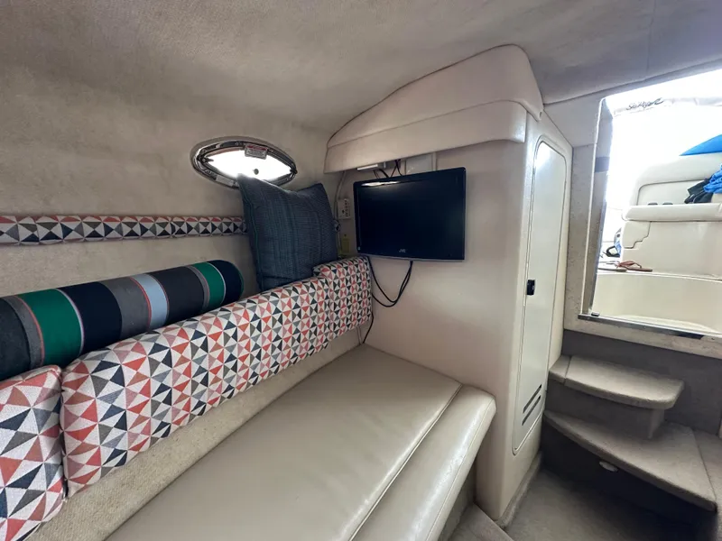 Slide: The Image of Interior of 2002 Sea Ray 240 Sundancer with patterned seating and wall-mounted TV. - 18