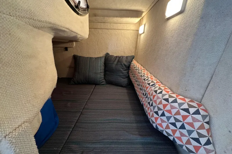 Slide: The Image of 2002 Sea Ray 240 Sundancer cabin interior with cushions and patterned upholstery. - 20