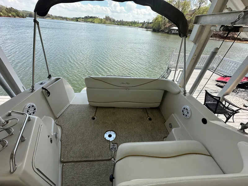 Slide: The Image of 2002 Sea Ray 240 Sundancer boat interior with seating, overlooking a serene lake view. - 6