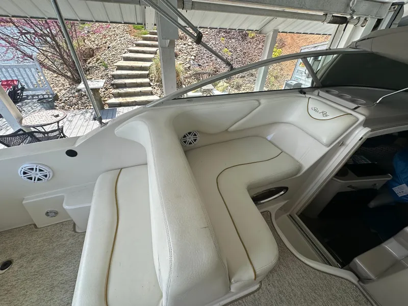 Slide: The Image of 2002 Sea Ray 240 Sundancer boat interior with white seating and dashboard. - 8