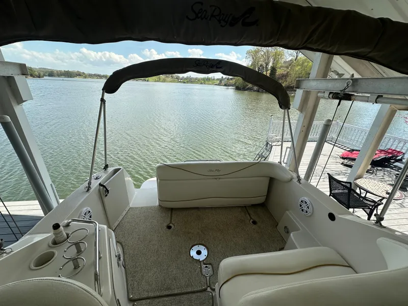 Slide: The Image of 2002 Sea Ray 240 Sundancer boat interior with lake view, featuring seating and canopy. - 9