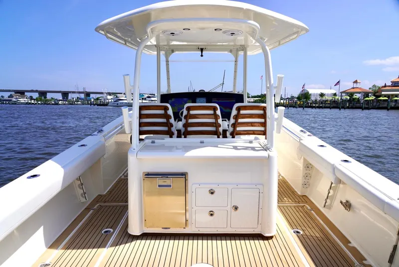 Slide: The Image of 2020 Cobia 350 Center Console boat with spacious deck and seating, docked by the waterfront. - 10