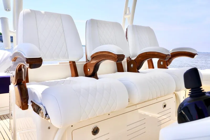 Slide: The Image of Luxurious seating on 2020 Cobia 350 Center Console boat with white upholstery and wooden accents. - 14