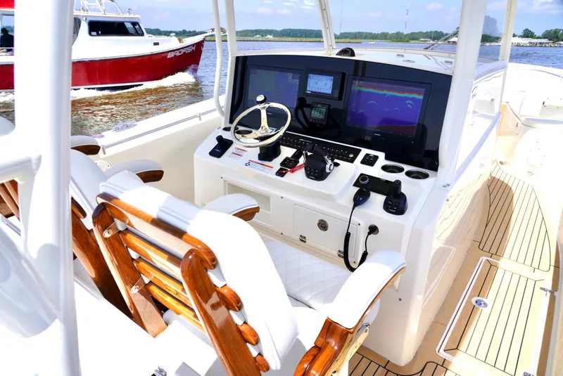 Slide: The Image of 2020 Cobia 350 Center Console boat interior with advanced navigation system and wooden seating. - 16