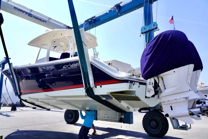 Slide: The Image of 2020 Cobia 350 Center Console boat being lifted by a marine travel lift. - 3