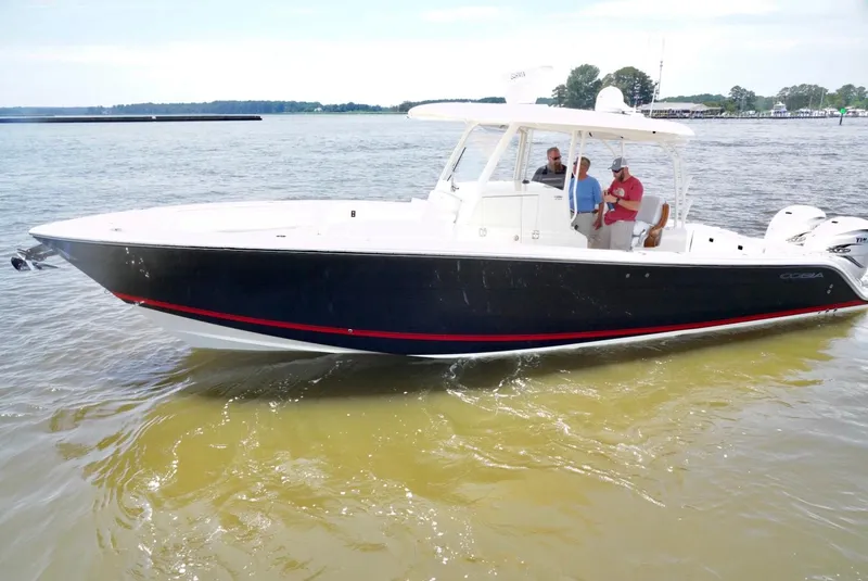 Slide: The Image of 2020 Cobia 350 Center Console boat cruising on a calm lake with passengers onboard. - 4