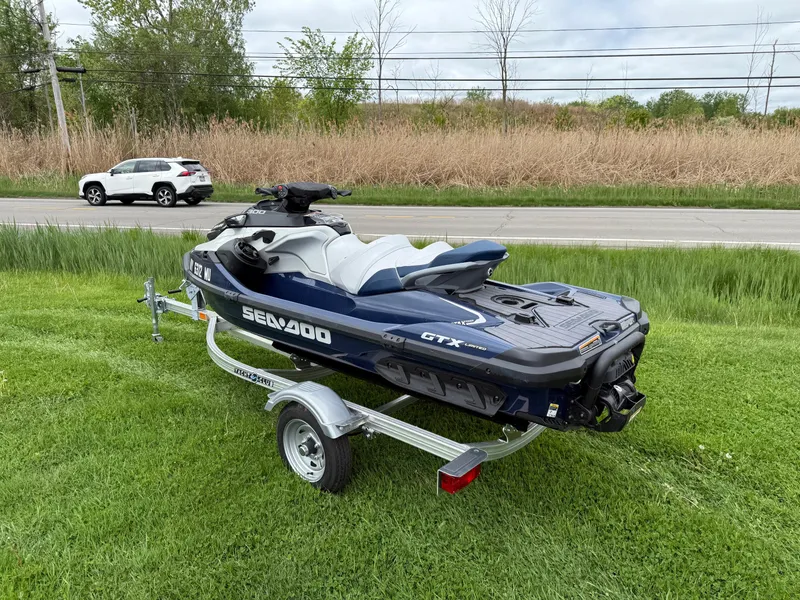Slide: The Image of 2024 Sea-Doo GTX Limited 300 Blue Abyss on trailer, parked on grass. - 2