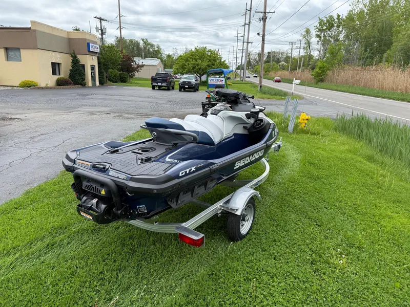 Slide: The Image of 2024 Sea-Doo GTX Limited 300 Blue Abyss on trailer, parked on grass. - 4