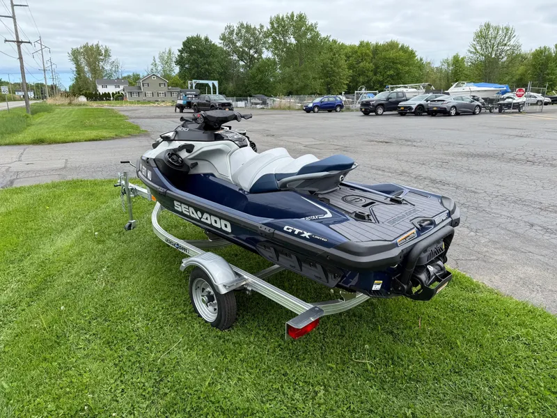 Slide: The Image of 2024 Sea-Doo GTX Limited 300 Blue Abyss on trailer, parked on grass. - 2