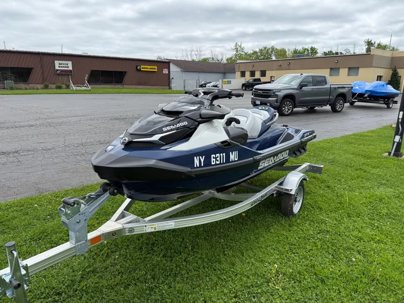 Slide: The Image of 2024 Sea-Doo GTX Limited 300 Blue Abyss on trailer, parked on grass. - 3