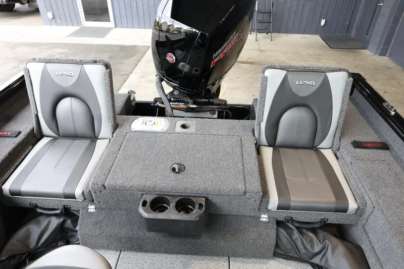 Slide: The Image of 2025 Lund 1875 Impact XS Sport boat interior with gray seating and motor. - 13