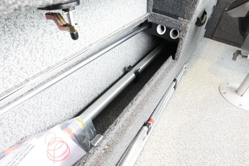 Slide: The Image of 2025 Lund 1875 Impact XS Sport boat storage compartment with fishing rod holders. - 15