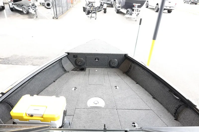 Slide: The Image of 2025 Lund 1875 Impact XS Sport boat interior with carpeted deck and storage compartments. - 16