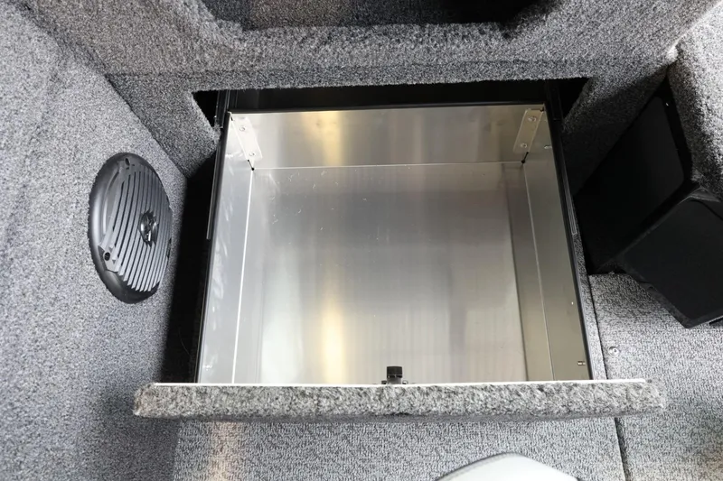 Slide: The Image of 2025 Lund 1875 Impact XS Sport boat storage compartment, open and empty, with carpeted interior. - 23