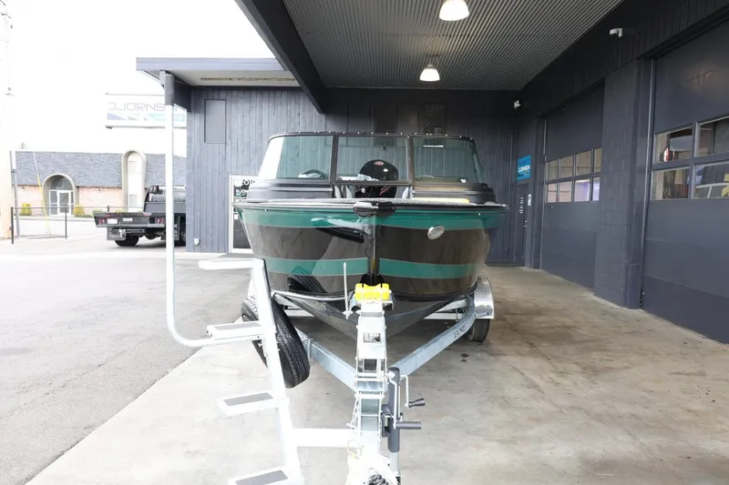 Slide: The Image of 2025 Lund 1875 Impact XS Sport boat on trailer in a garage setting. - 3