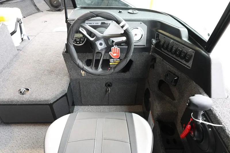Slide: The Image of 2025 Lund 1875 Impact XS Sport boat interior with steering wheel and control panel. - 35