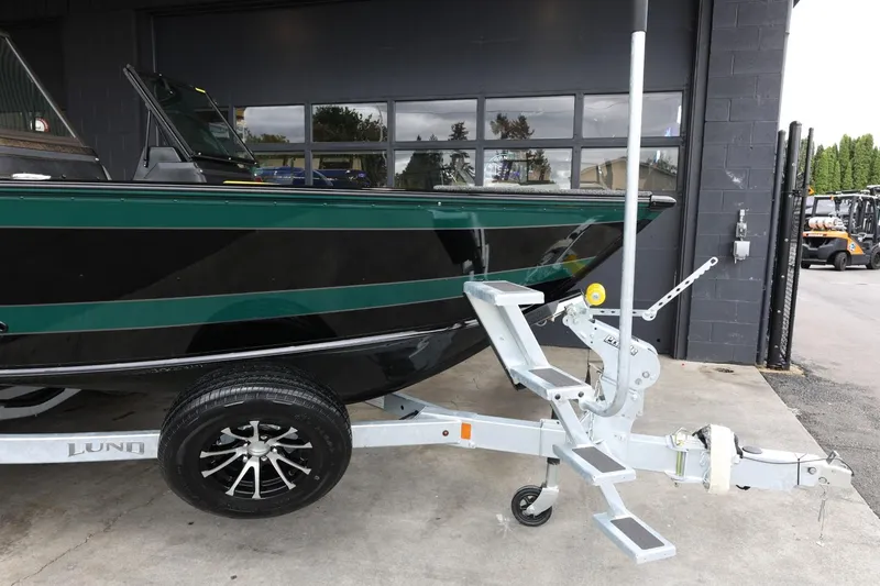 Slide: The Image of 2025 Lund 1875 Impact XS Sport boat on trailer, parked outside a building. - 38