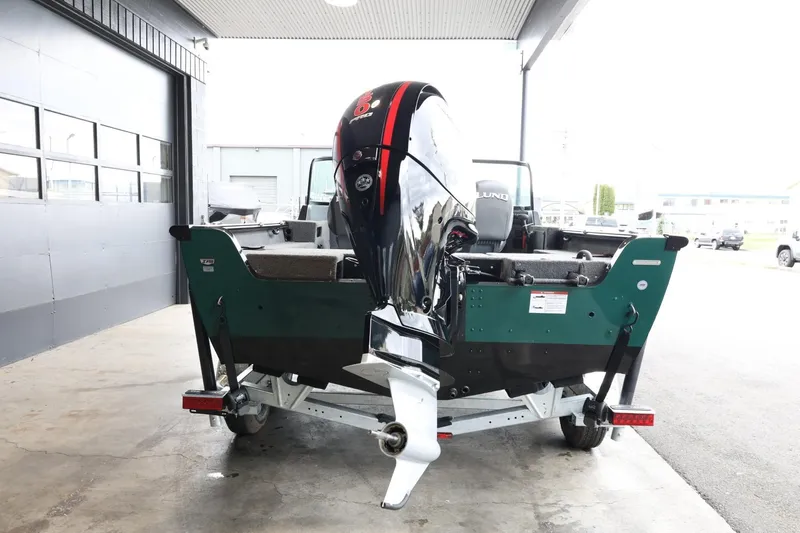 Slide: The Image of 2025 Lund 1875 Impact XS Sport boat on trailer, rear view in a garage. - 7