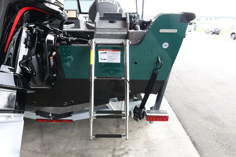 Slide: The Image of 2025 Lund 1875 Impact XS Sport boat with ladder and motor, rear view. - 9