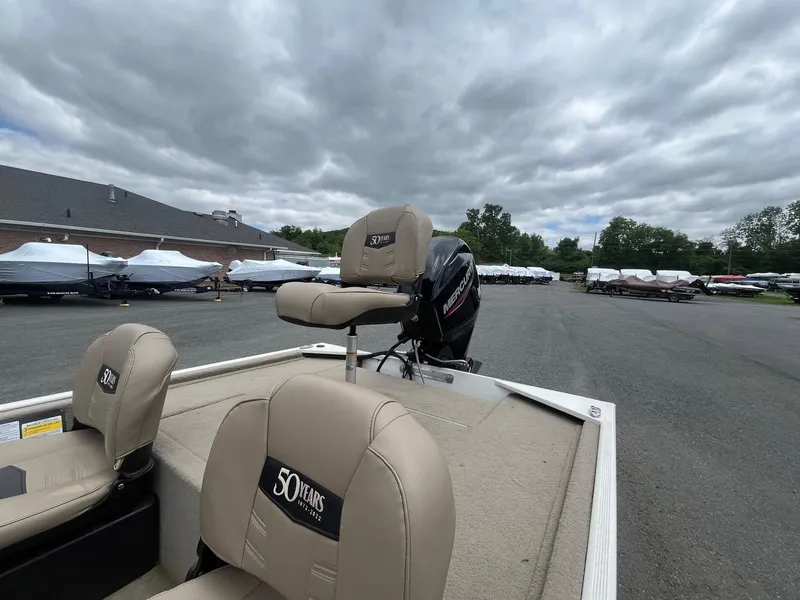 Slide: The Image of 2022 Tracker Bass Tracker Classic XL boat with beige seats in a marina setting. - 14