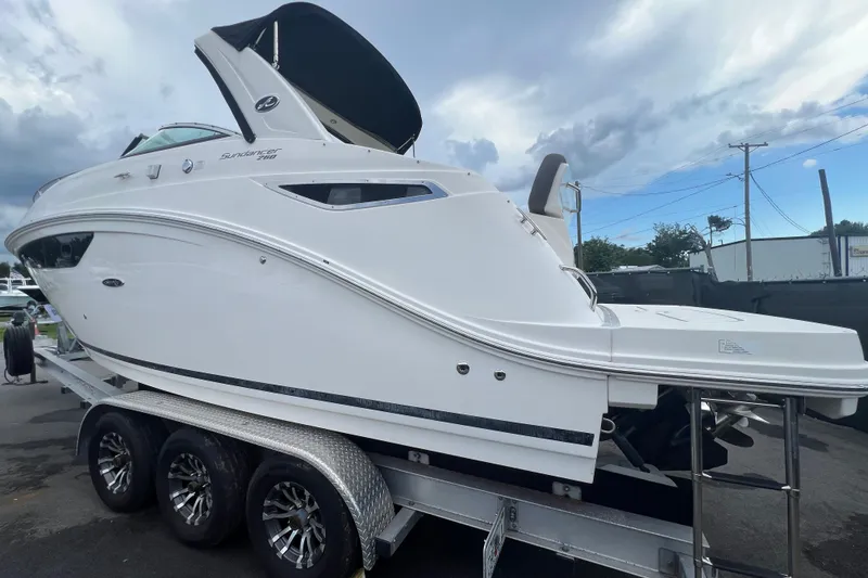 Slide: The Image of 2014 Sea Ray 260 Sundancer boat interior with seating and dashboard, parked in a marina. - 10