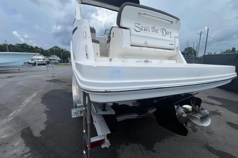 Slide: The Image of 2014 Sea Ray 260 Sundancer boat interior with helm, seating, and compact kitchenette. - 11