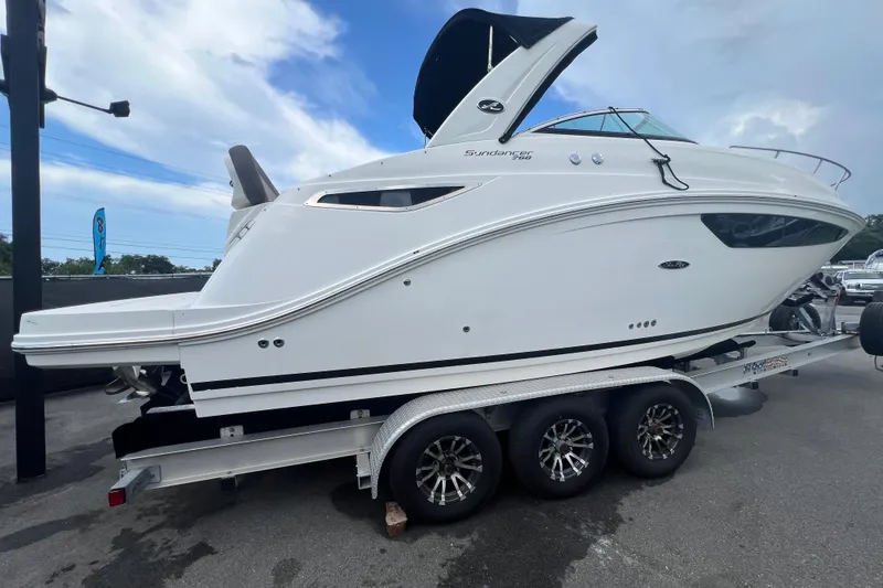 Slide: The Image of 2014 Sea Ray Sundancer 260 boat on trailer under clear blue sky. - 2