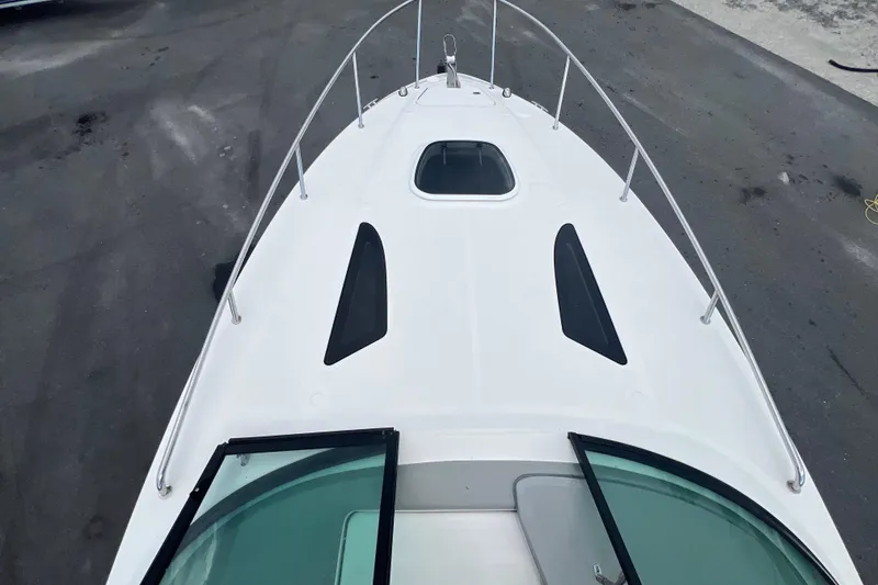 Slide: The Image of 2014 Sea Ray 260 Sundancer cabin interior with seating and wooden table. - 23