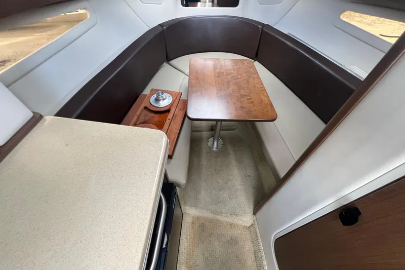 Slide: The Image of Interior of 2014 Sea Ray 260 Sundancer boat with beige seating and wooden accents. - 28
