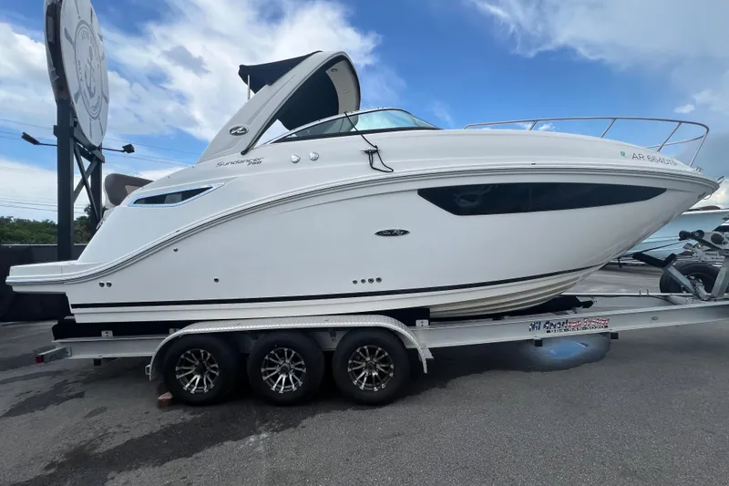 Slide: The Image of 2014 Sea Ray Sundancer 260 boat with "Seas the Day" text, docked under clear sky. - 3