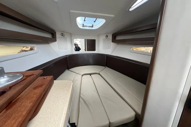 Slide: The Image of 2014 Sea Ray 260 Sundancer boat interior with cushioned seating and cup holders. - 32