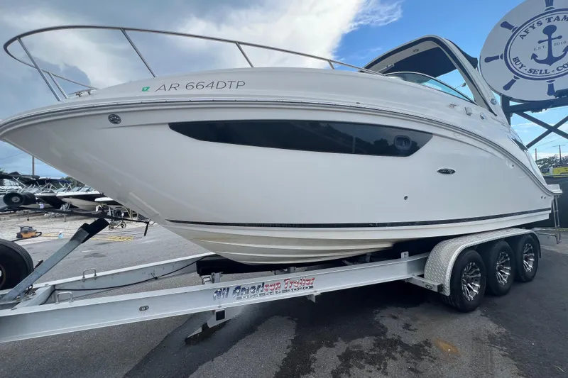 Slide: The Image of 2014 Sea Ray Sundancer 260 boat on trailer, parked outdoors under clear sky. - 8